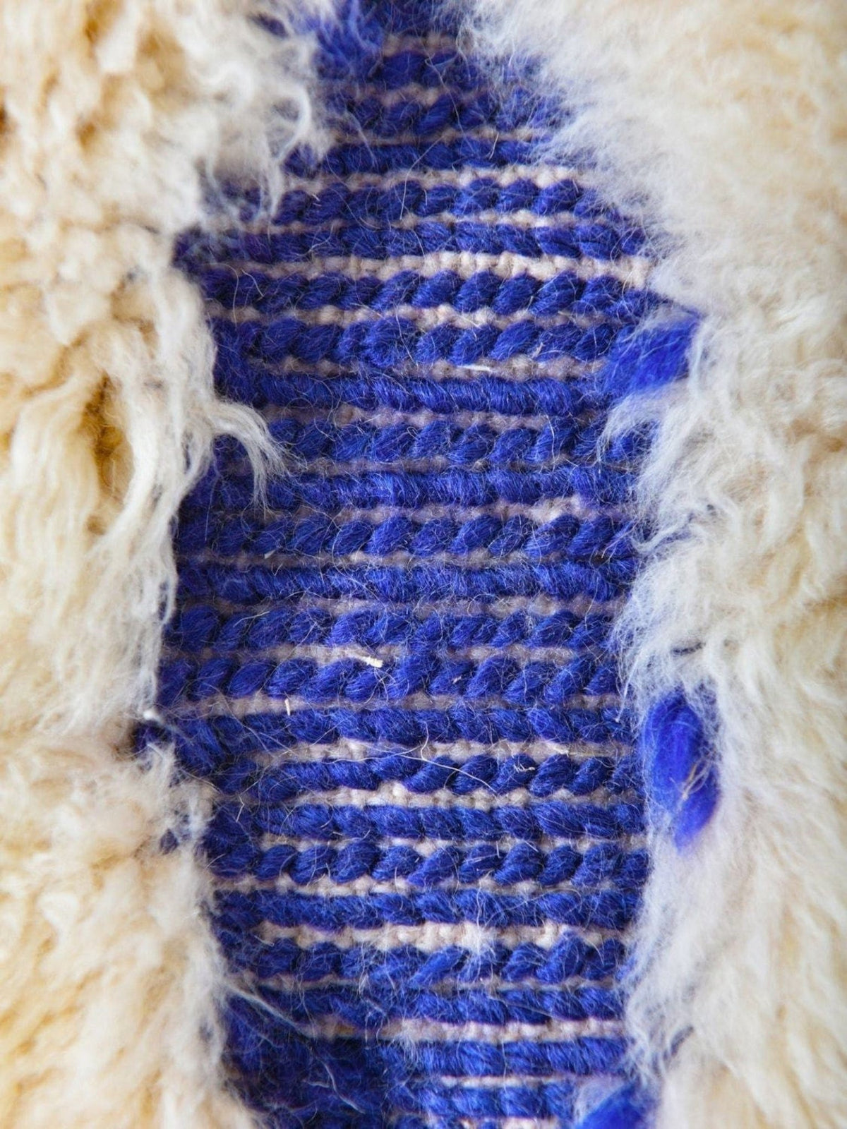 Detail view of a blue and cream rug showcasing a textured pattern.