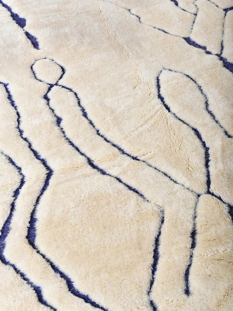 Close-up detail showing abstract lines on a blue and cream Moroccan rug.