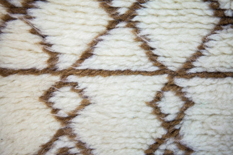 Front view of the brown striped Moroccan rug showcasing soft texture and tribal designs in black and off-white.