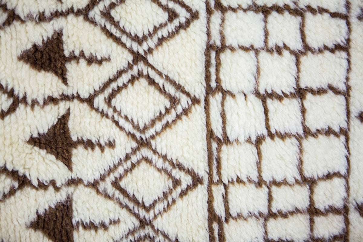 Close-up detail of the Moroccan rug's diamond pattern in black and off-white with a textured surface.