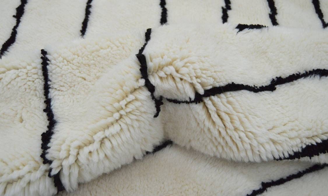 Close-up detail of a Moroccan rug highlighting bold lines and soft fibers.