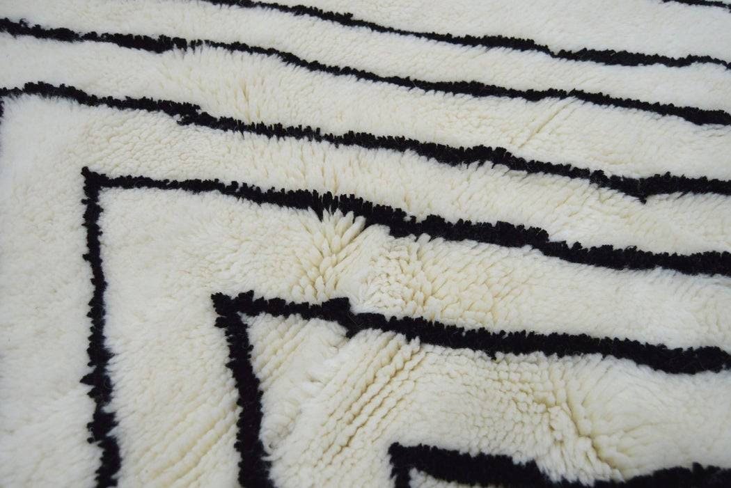 Close-up detail of a Moroccan rug featuring a zigzag pattern in black and white.