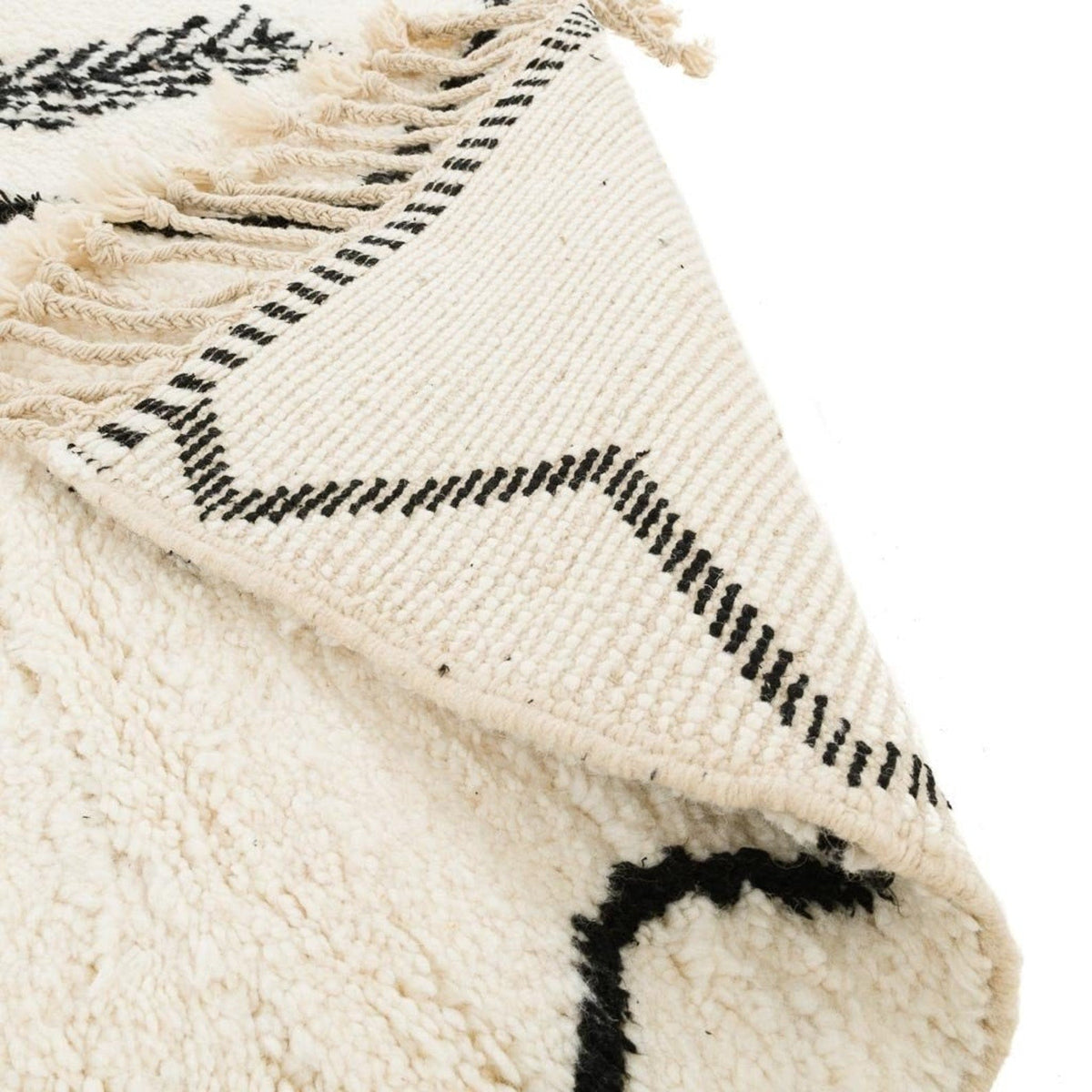 Close-up detail of the Moroccan rug highlighting its textured surface and fringe detail.