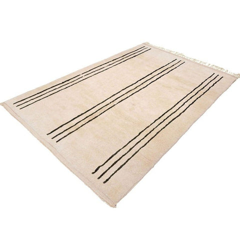 Lifestyle shot of the beige striped Moroccan rug in a natural setting.