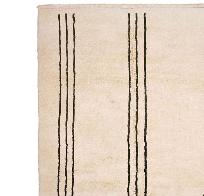 Close-up detail of the striped pattern on the beige Moroccan rug.