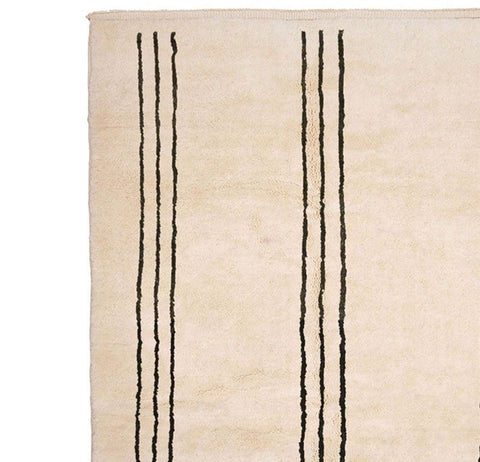Close-up detail of the striped pattern on the beige Moroccan rug.