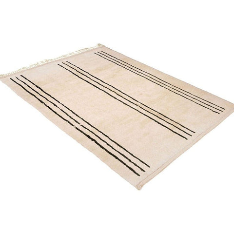 Lifestyle shot of the beige striped Moroccan rug in a natural setting.