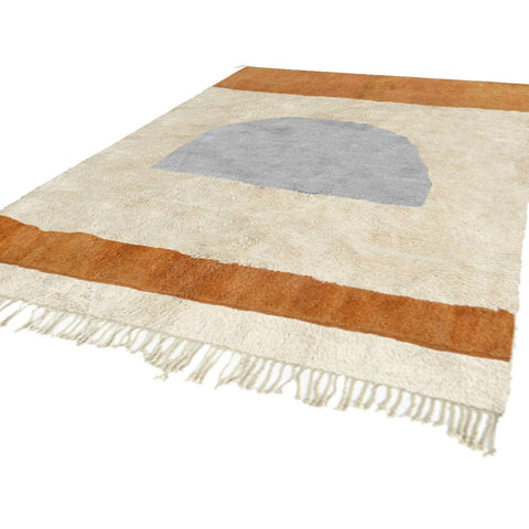 Close-up detail showcasing the abstract design of the Moroccan rug in cream, orange, and gray.