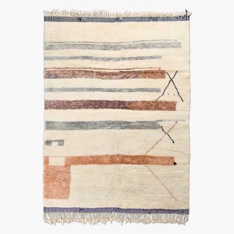 Detail close-up of a cream and orange geometric area rug with fringe edges.