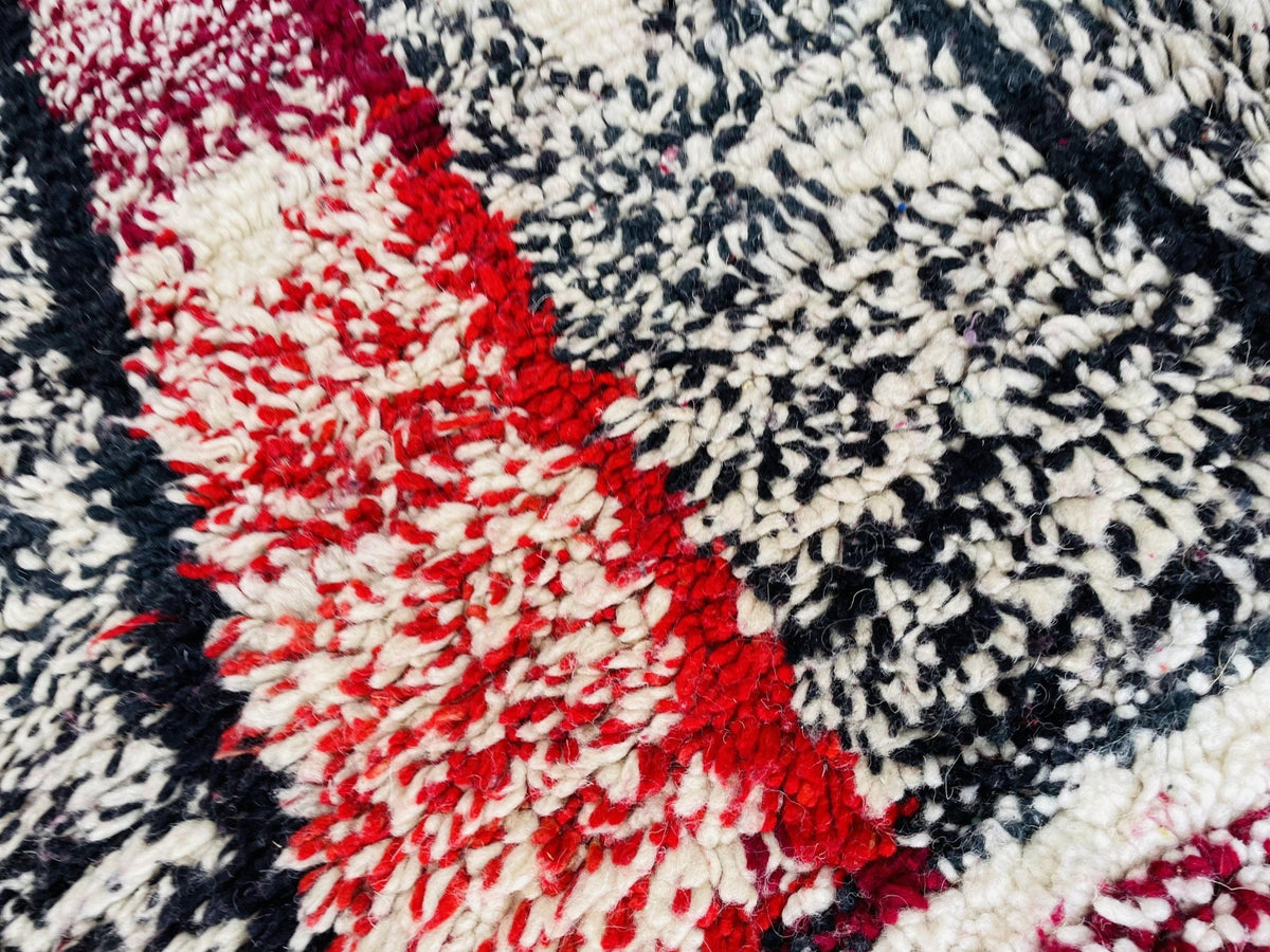 Close-up of a black and white Moroccan rug featuring a geometric pattern.