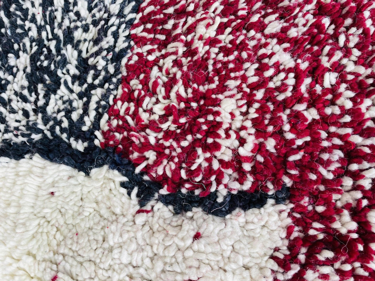 Close-up detail showcasing the color contrast of a red and black textured Moroccan rug.