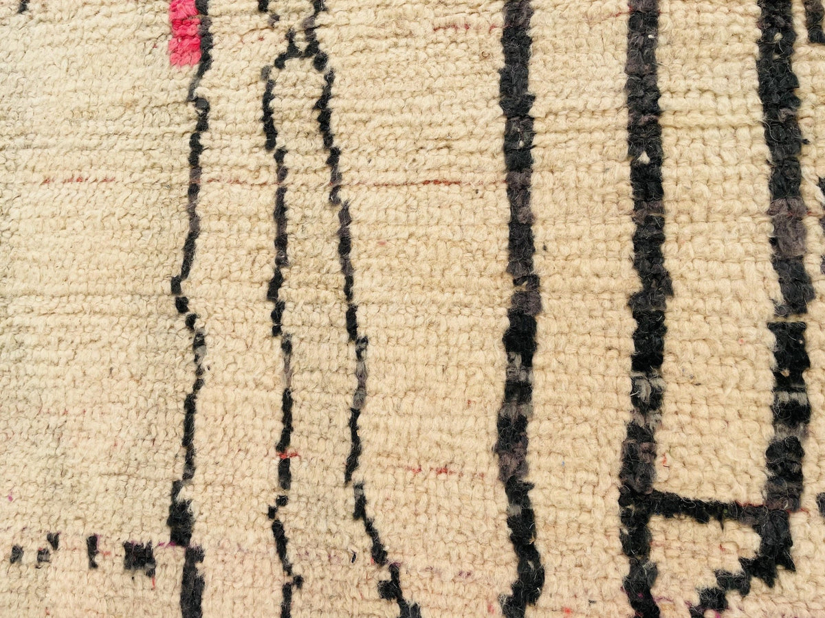 Close-up detail of abstract patterns on a pink vintage Moroccan rug.