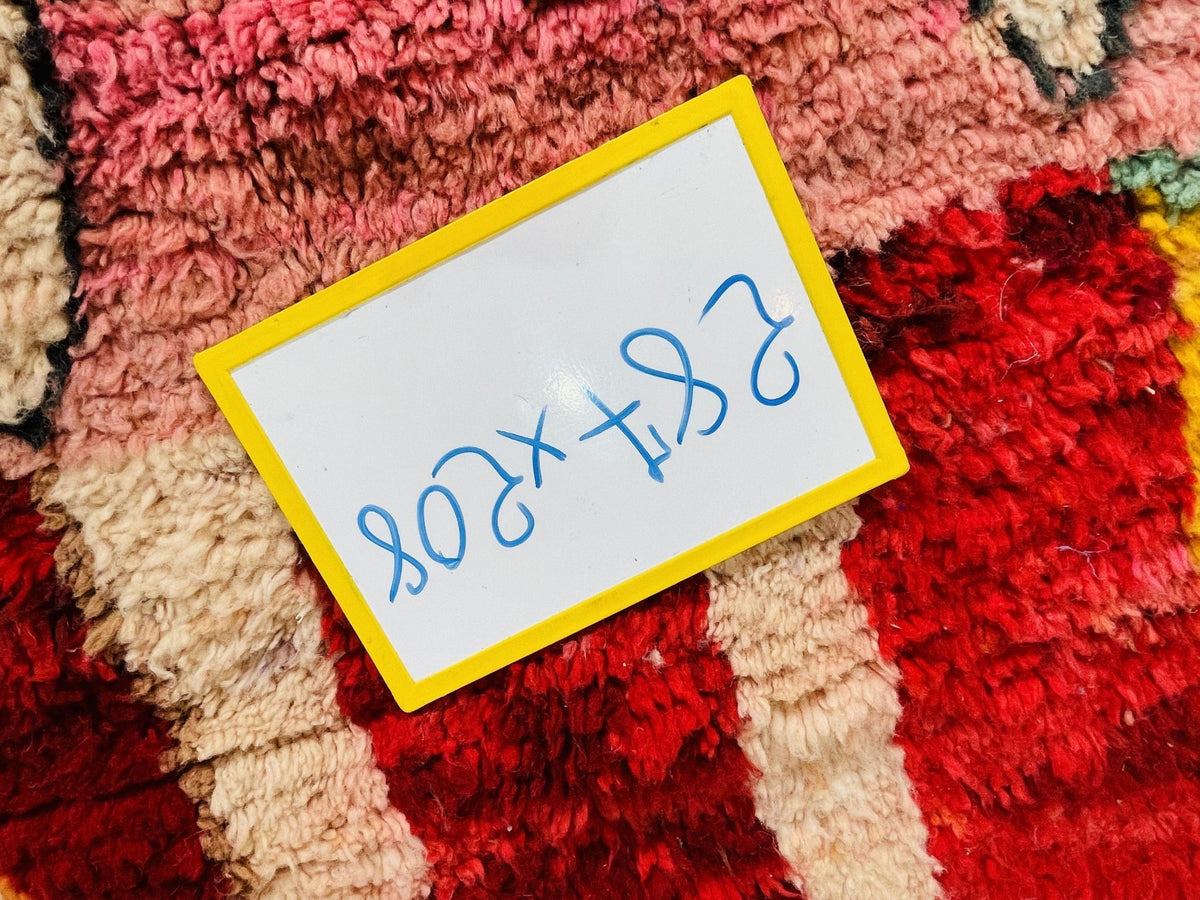Detail shot of a price tag on a vintage Moroccan rug with handwritten notes on a paper tag.