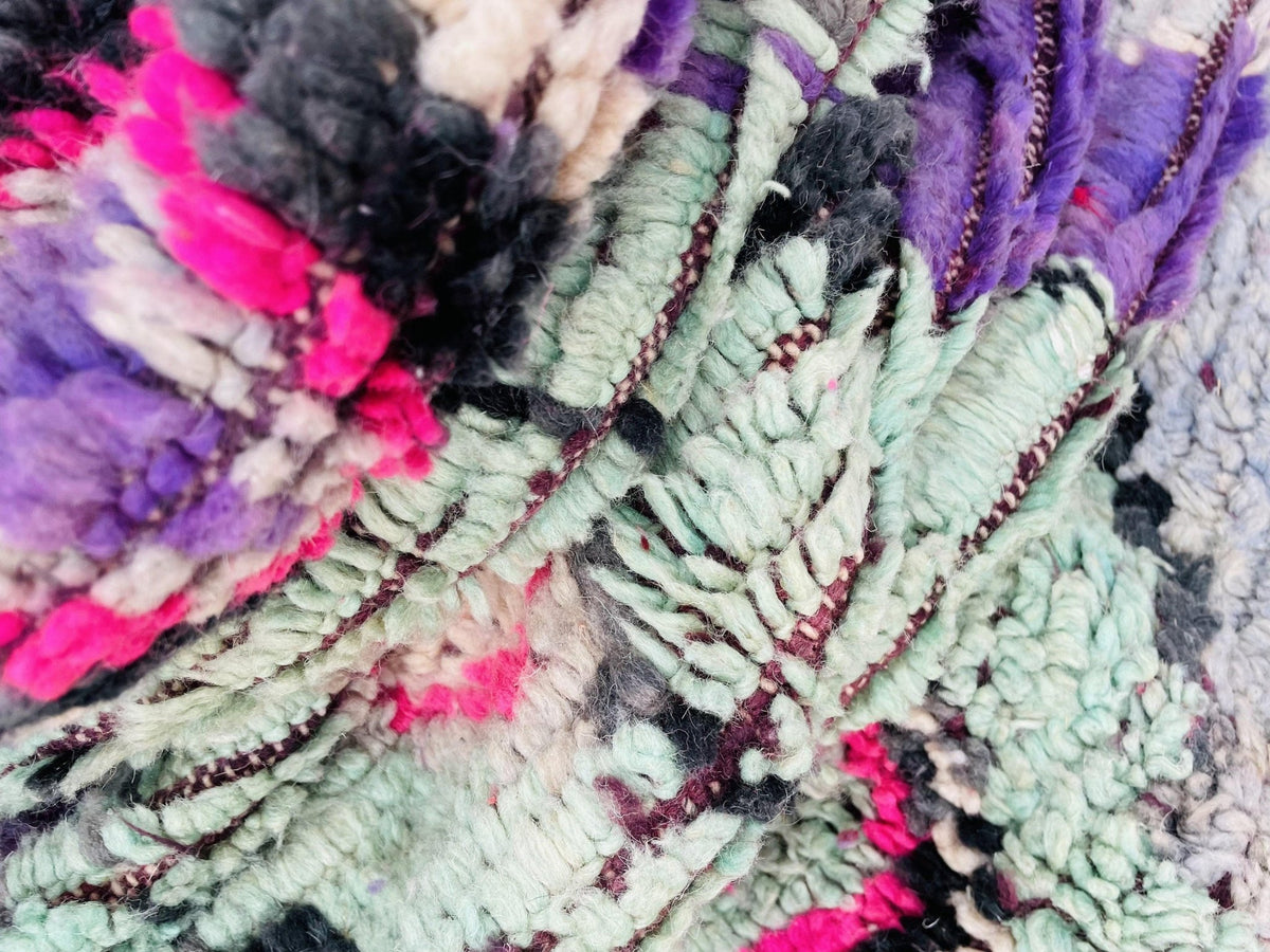 Close-up detail of a vintage Moroccan rug showcasing a textured pattern with colorful design.