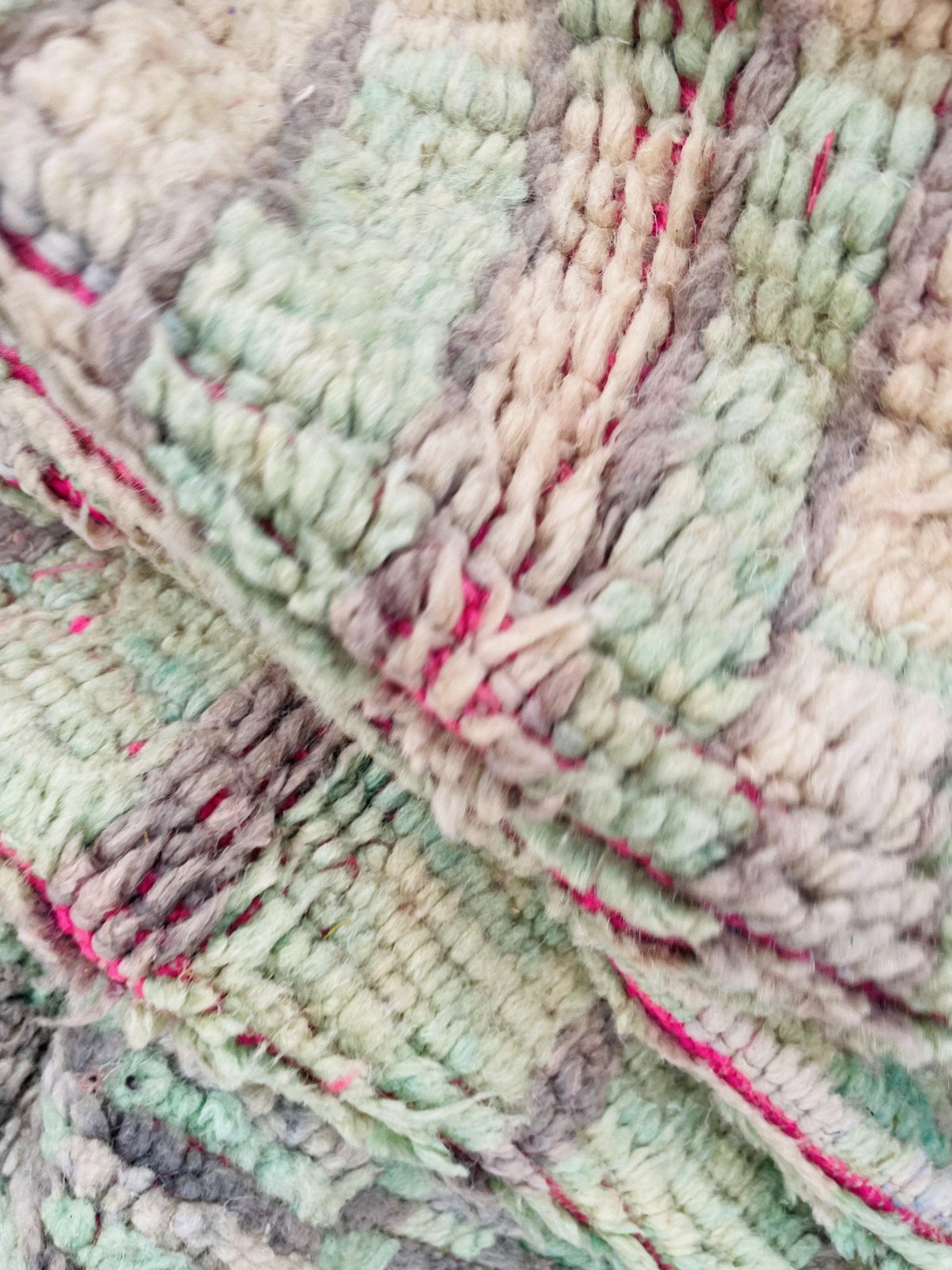 Close-up detail of the woven pattern and soft texture of the olive green vintage Moroccan rug.