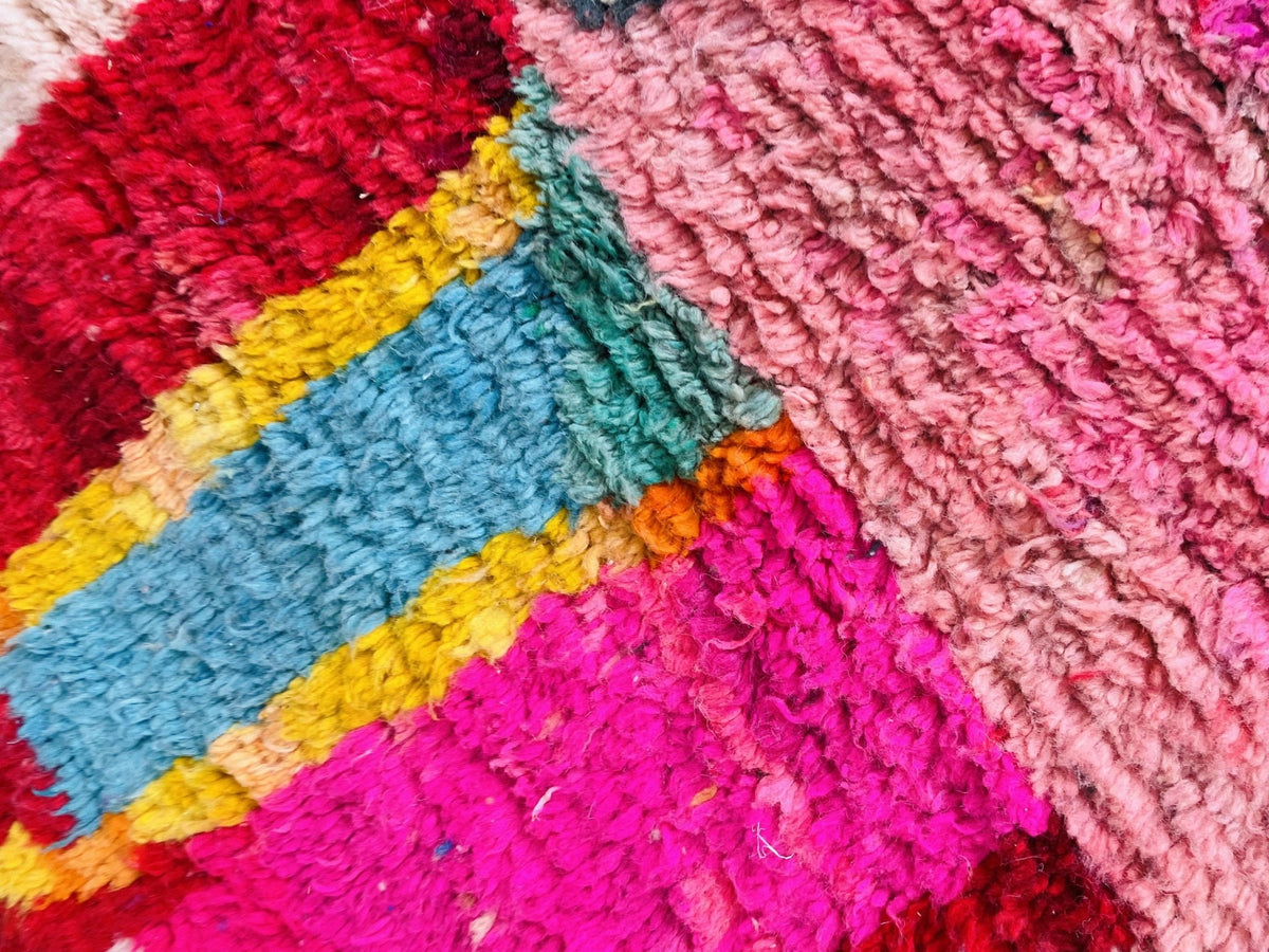 Close-up detail of a vintage Moroccan rug highlighting colorful patterns and textured fibers.