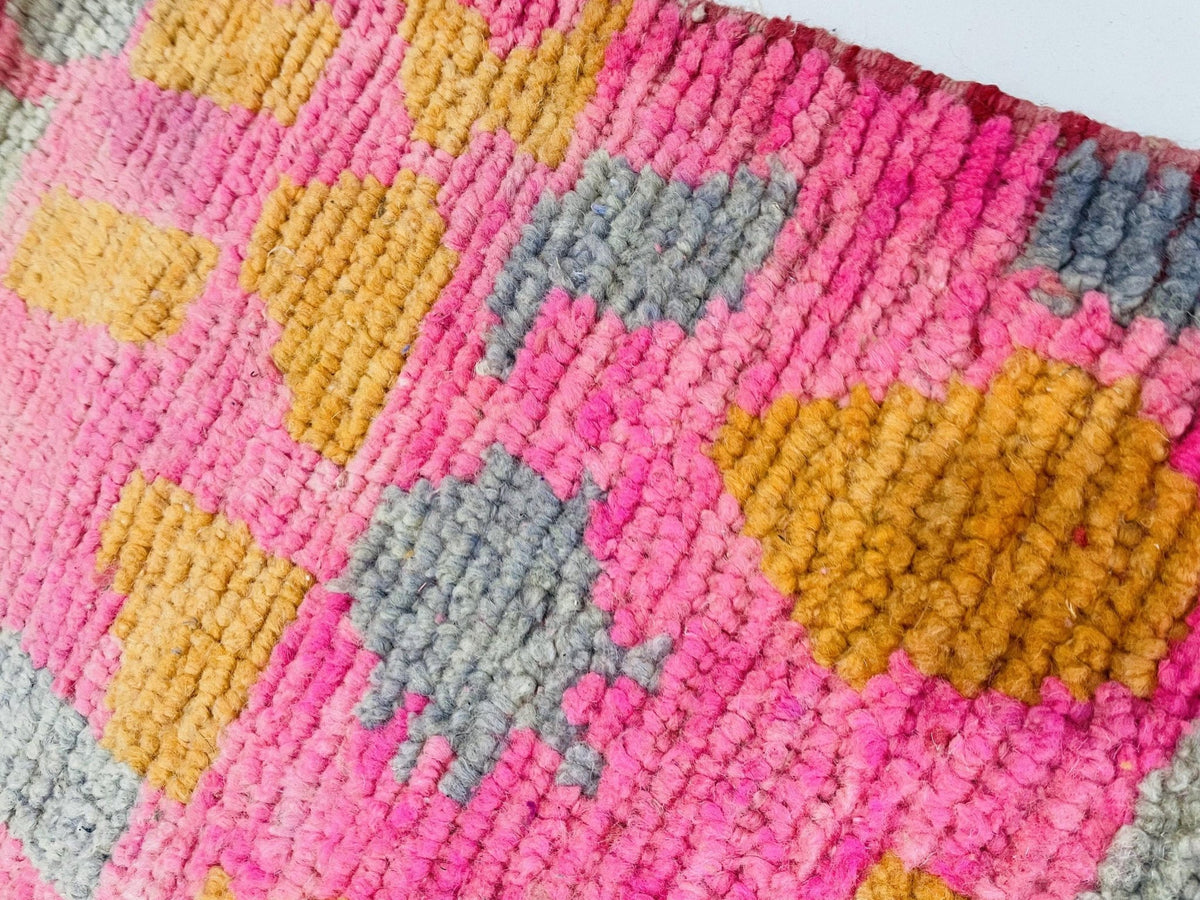 Detail shot highlighting the colorful woven pattern of a pink Moroccan rug.