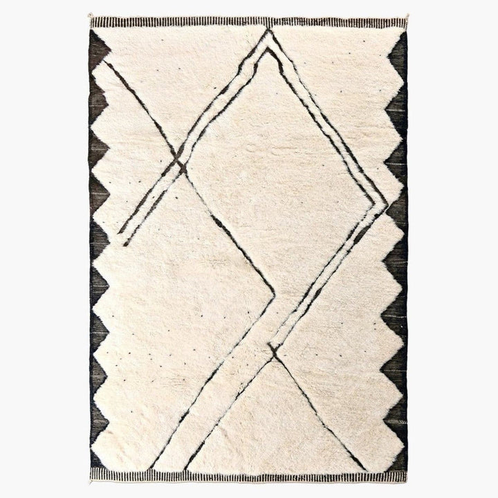 Front view of the cream and black geometric area rug with scalloped edges.