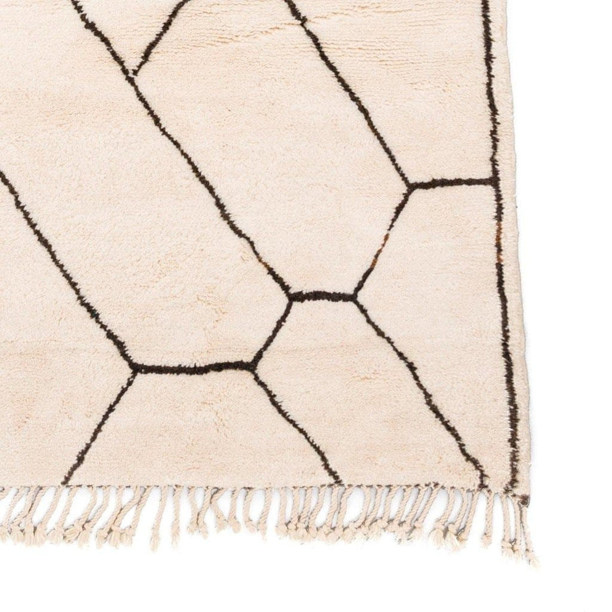 Detail shot of the edge of the geometric rug featuring fringe edges.