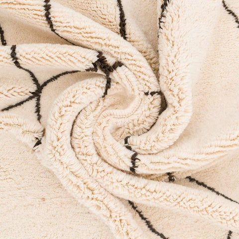 Close-up detail of the geometric black and white rug showcasing its woven design.