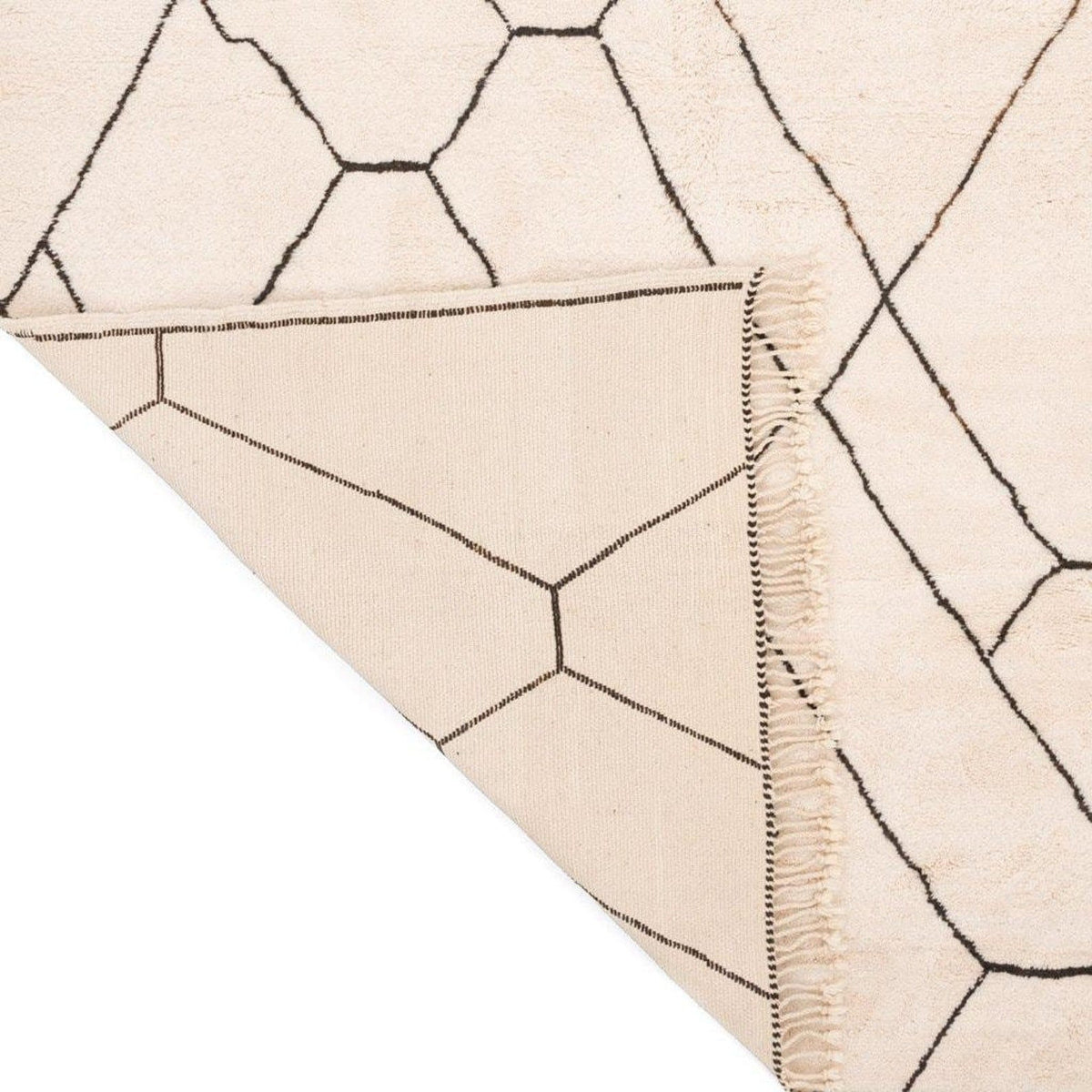 Close-up of the corner of the geometric rug highlighting its soft fabric.