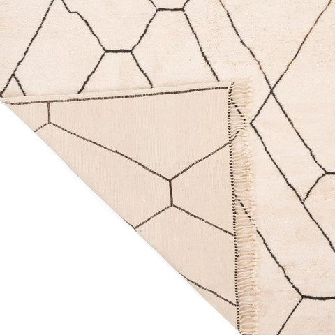 Close-up of the corner of the geometric rug highlighting its soft fabric.