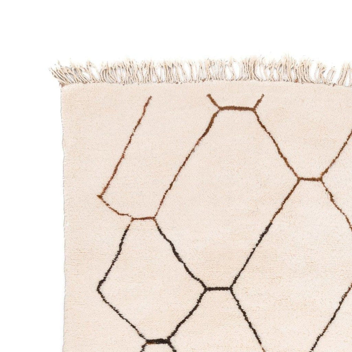 Close-up detail of the geometric rug with fringe detail in black, white, and brown.