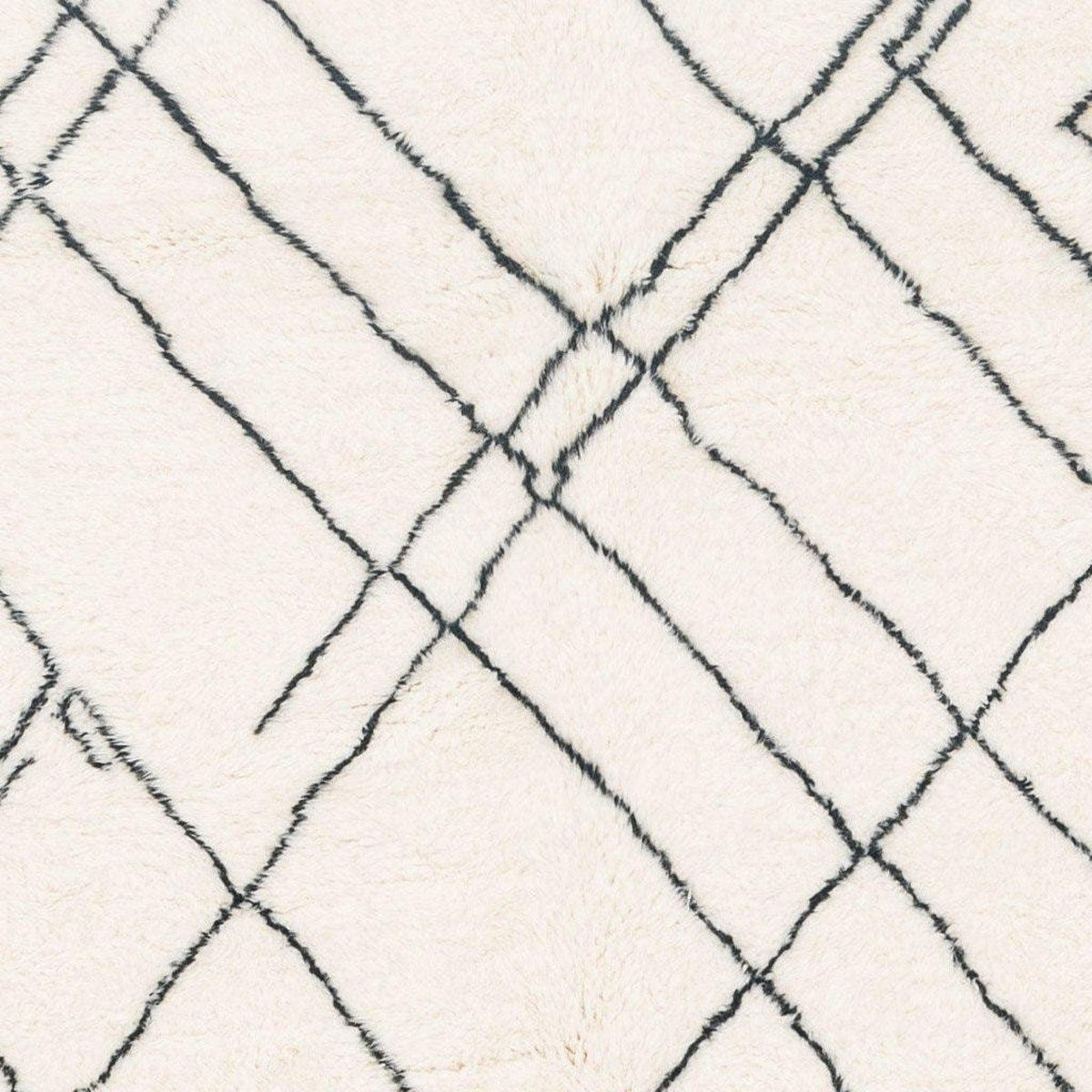 Close-up of the geometric white area rug highlighting its geometric pattern.