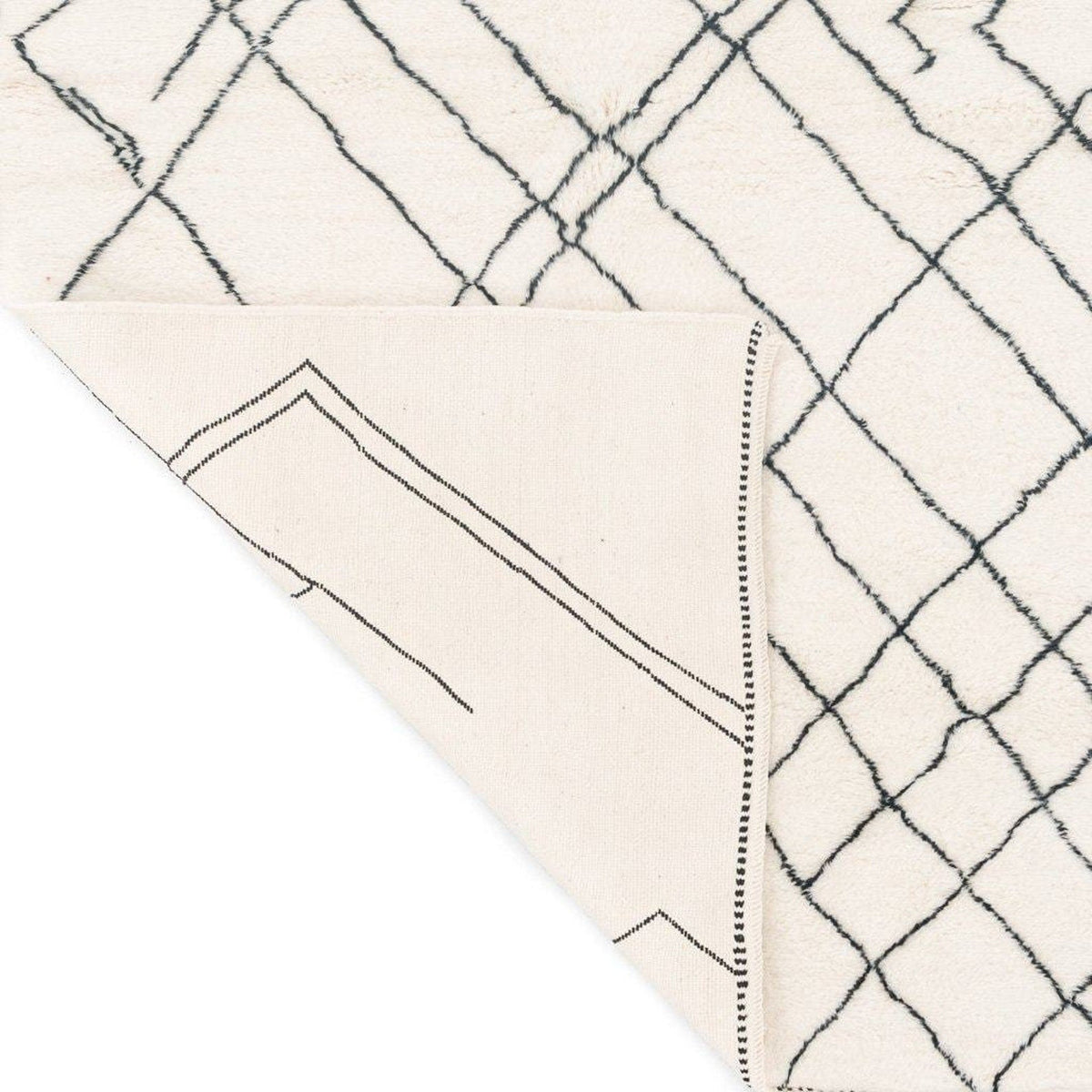 Detail view of the geometric white area rug from a corner perspective.