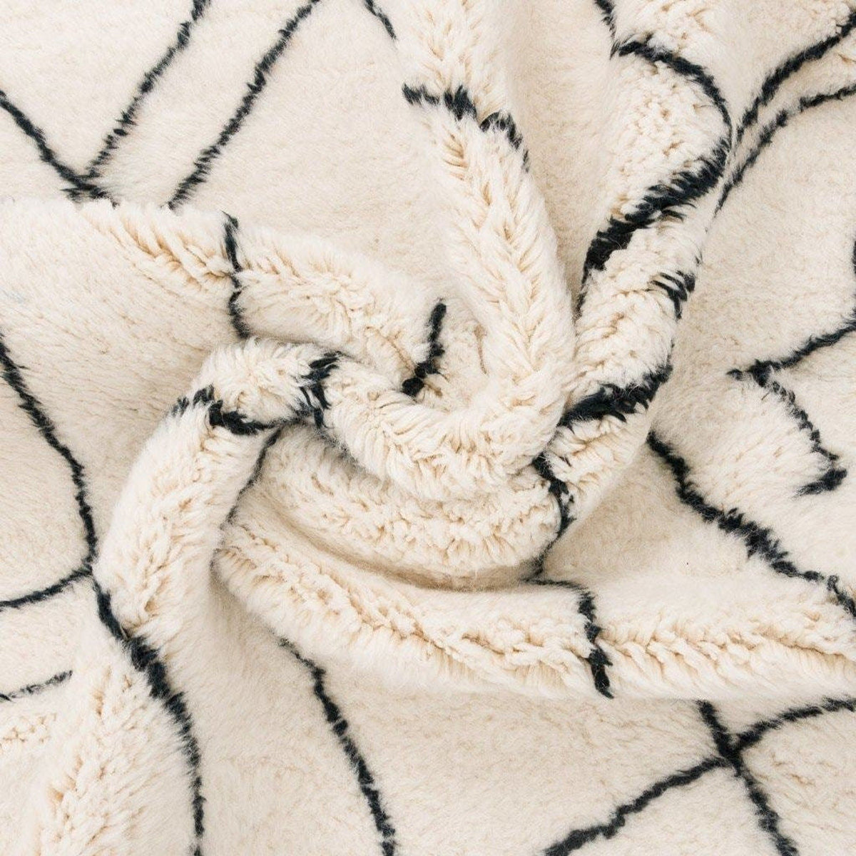 Detail shot of the geometric white area rug with a knotted design.