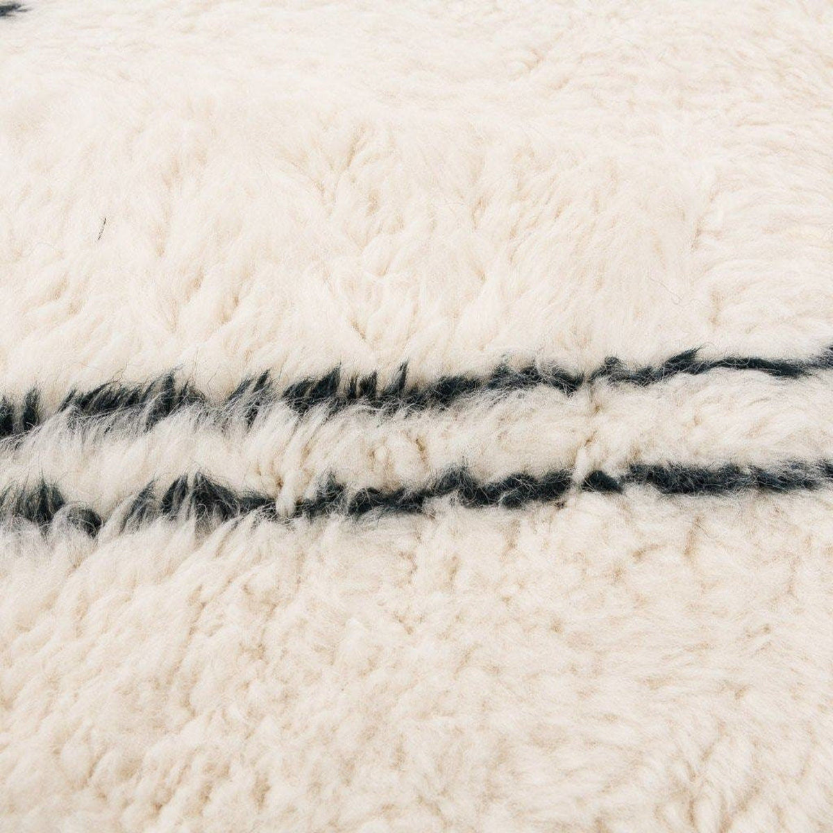 Close-up detail of the geometric white area rug highlighting its textured surface.