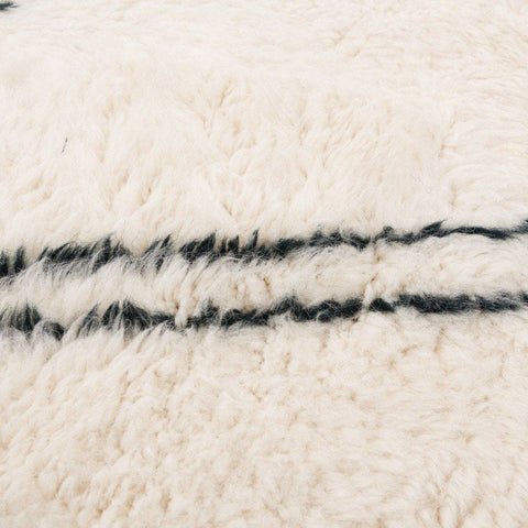 Close-up detail of the geometric white area rug highlighting its textured surface.