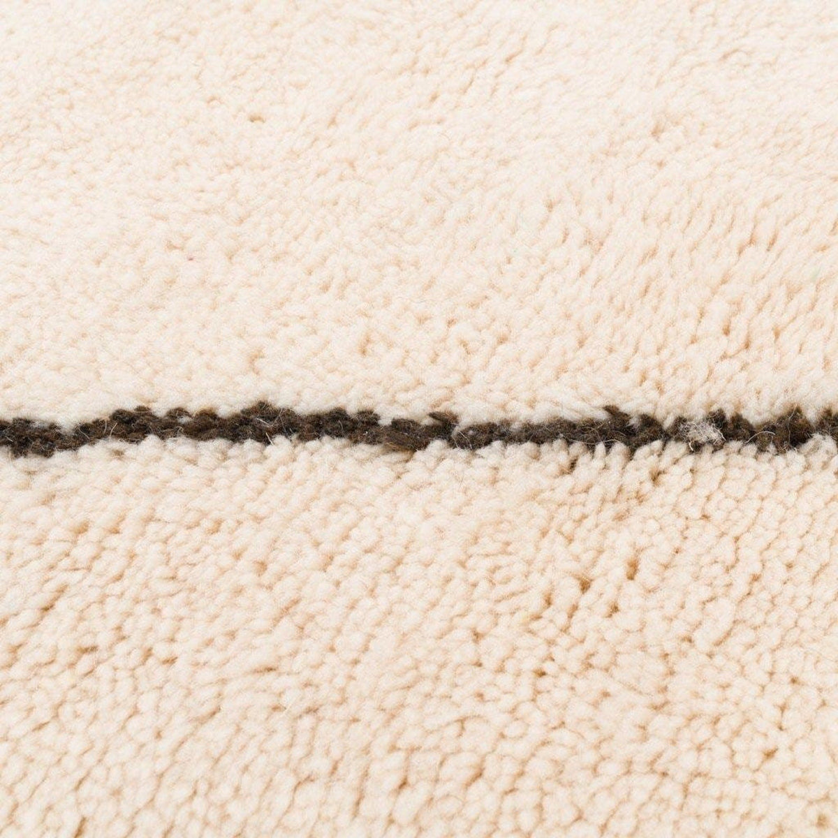 Detail view of the white area rug featuring black line details.