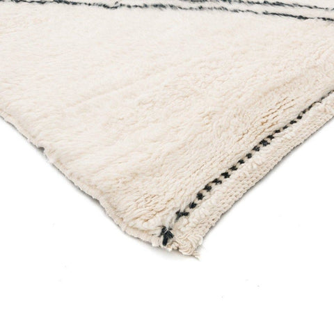 Close-up of the geometric white area rug emphasizing its geometric pattern.