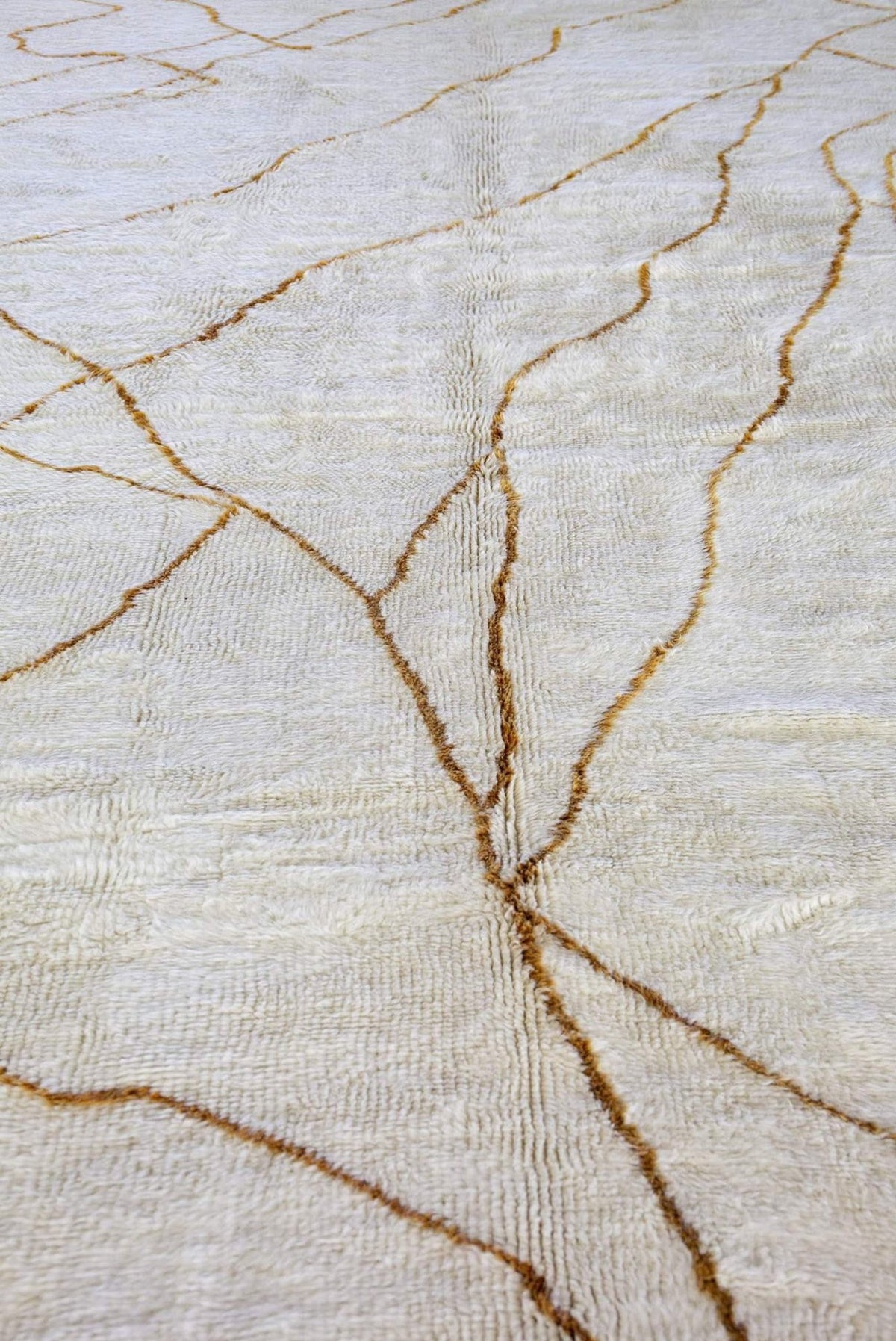 Close-up detail of the textured surface featuring gold lines on the abstract rug.