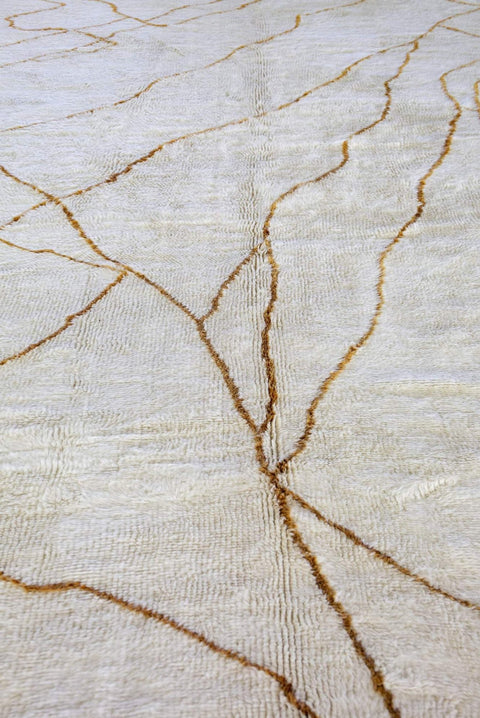 Close-up detail of the textured surface featuring gold lines on the abstract rug.