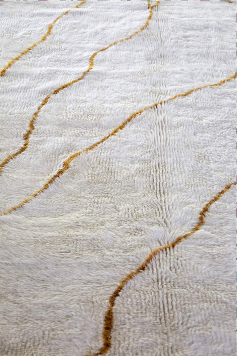 Close-up detail showing gold streaks on the soft fabric of the abstract rug.
