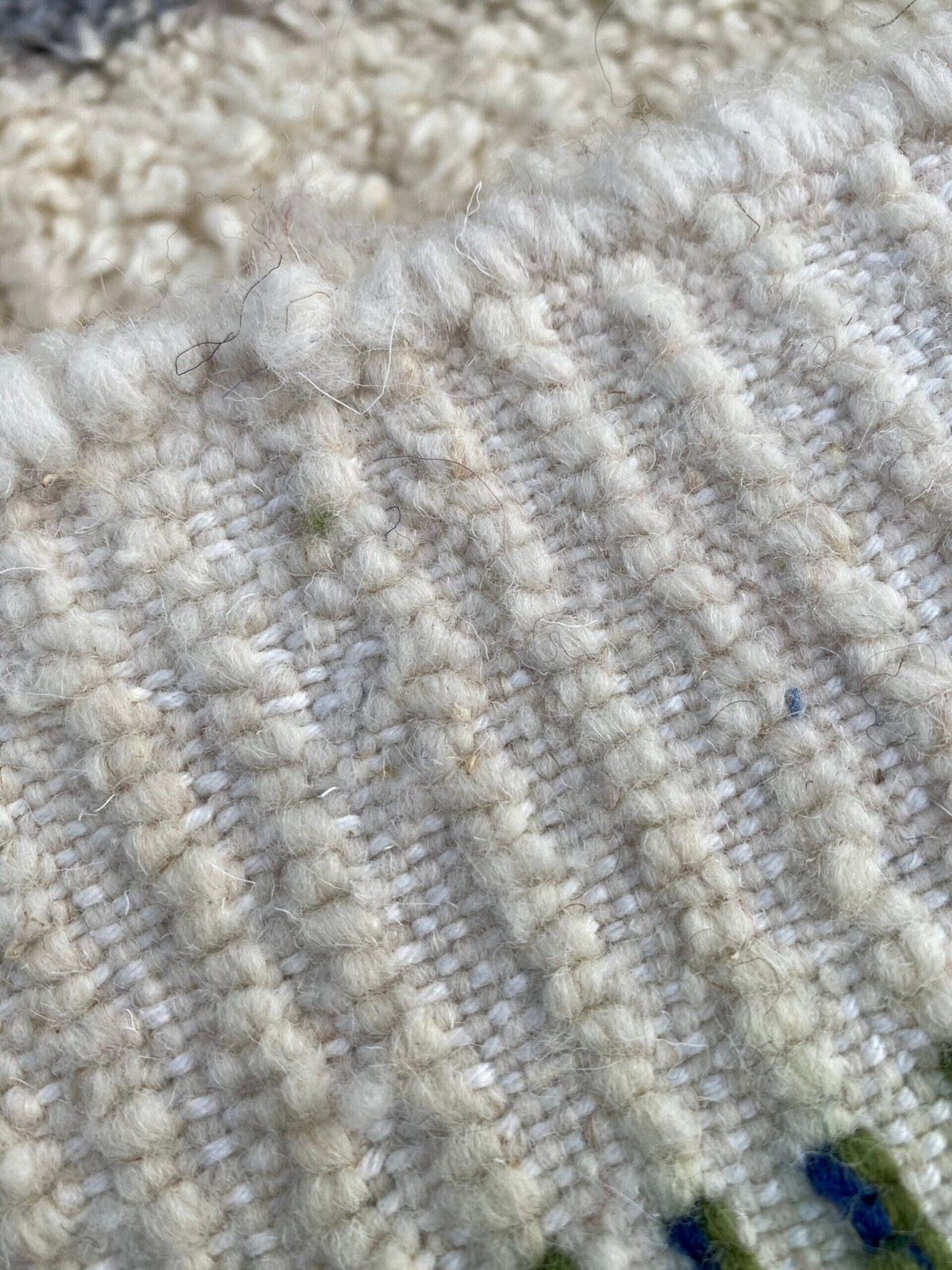 Detail view of a white Moroccan rug with a textured pattern and Berber design.