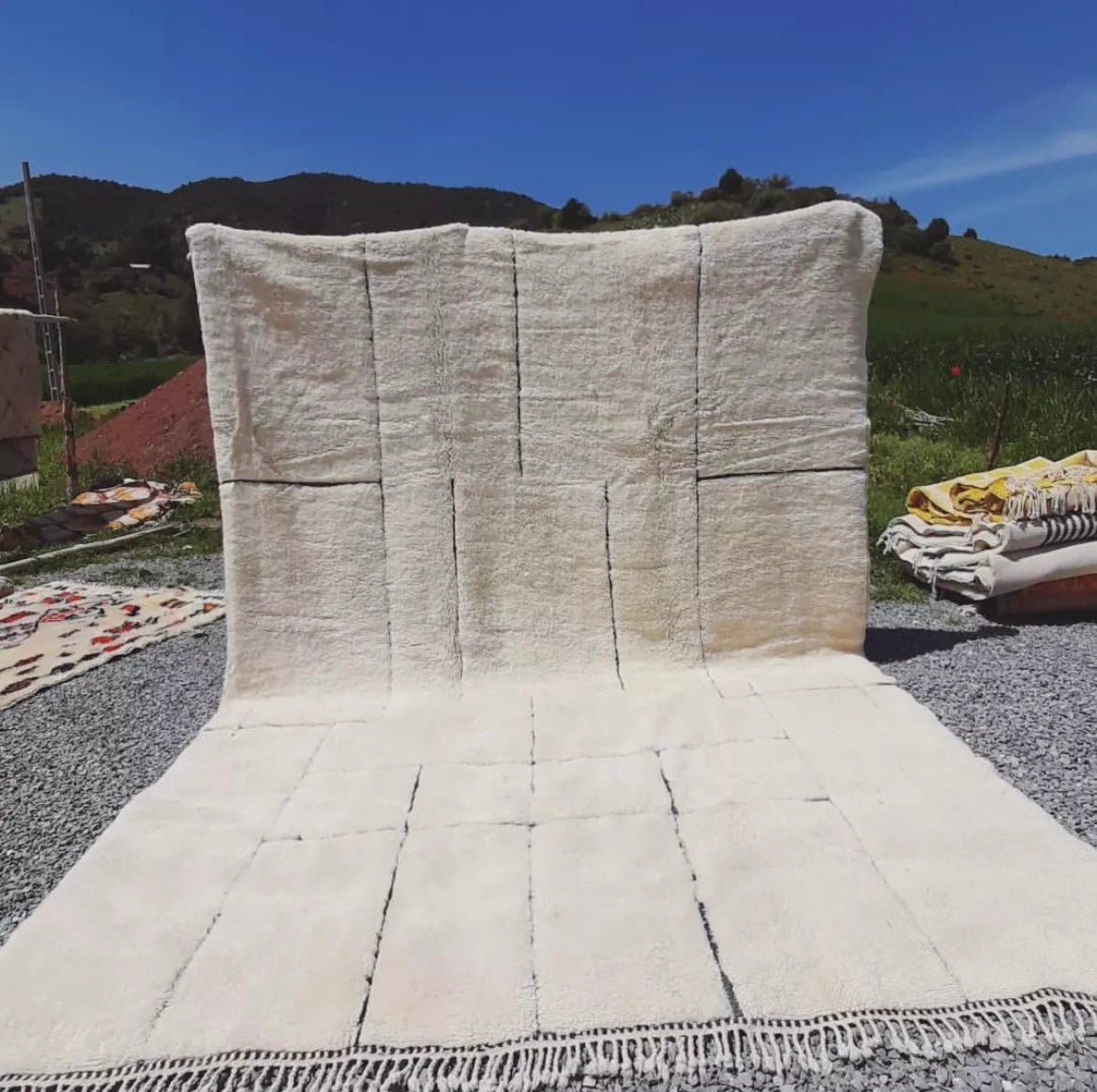 Lifestyle view of a beige and white Moroccan Berber rug, highlighting its design in a natural background.