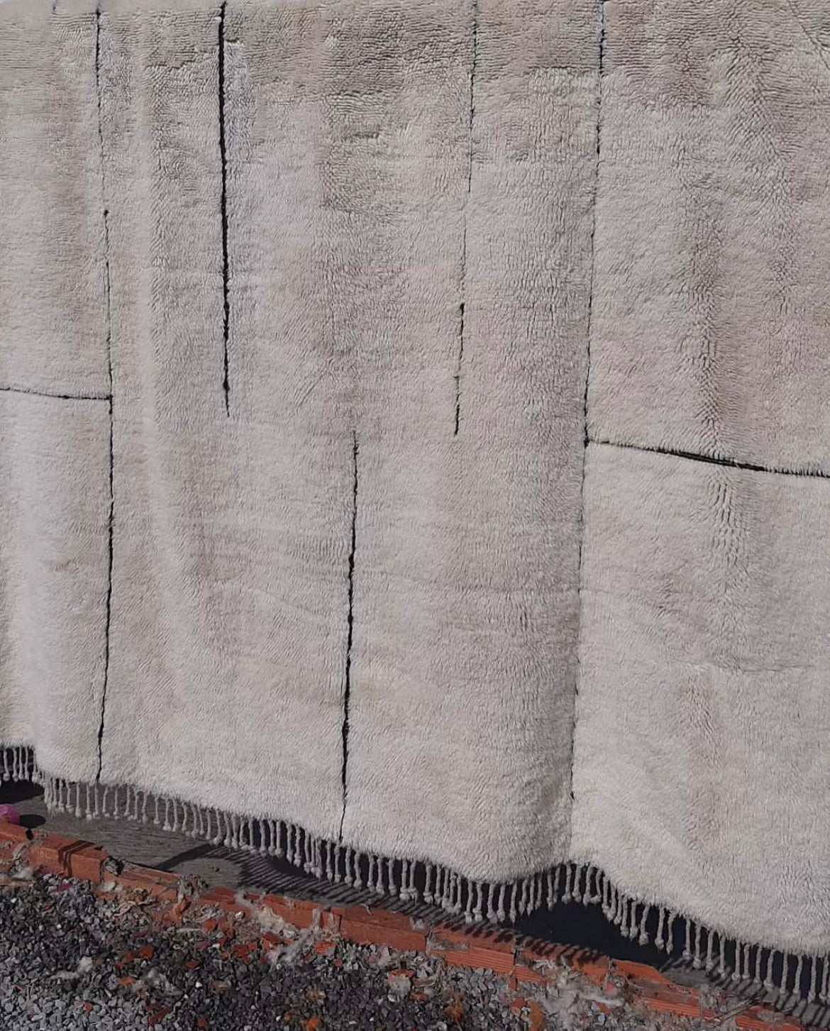 Close-up detail of a white Moroccan rug, showcasing its intricate patterns.
