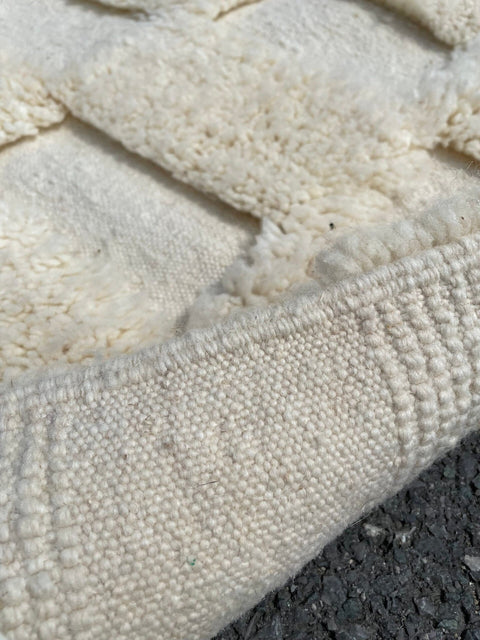Detail close-up of a white checkered rug emphasizing tufted texture.