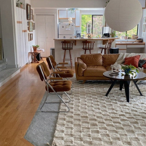 Lifestyle shot of a checkered Moroccan rug with a sectional sofa in a natural setting.
