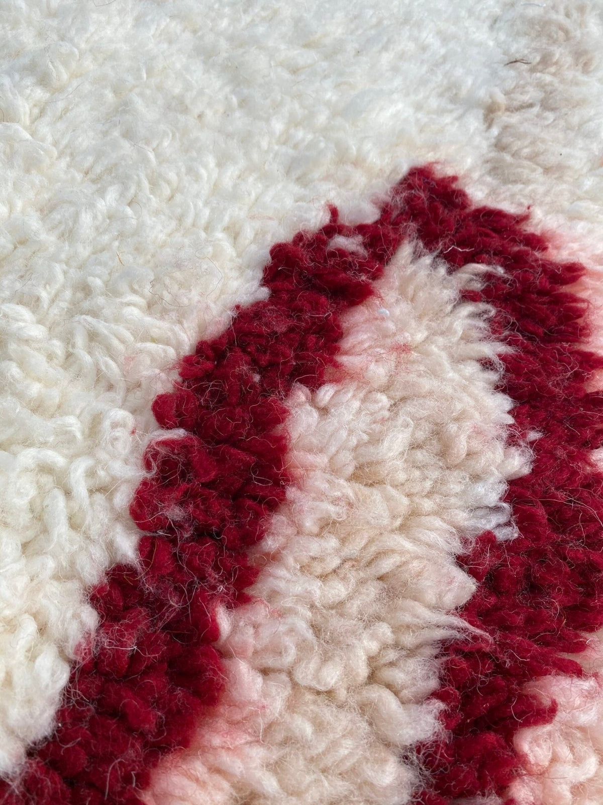 Close-up detail of a bohemian rug displaying a striped pattern and textured fibers.