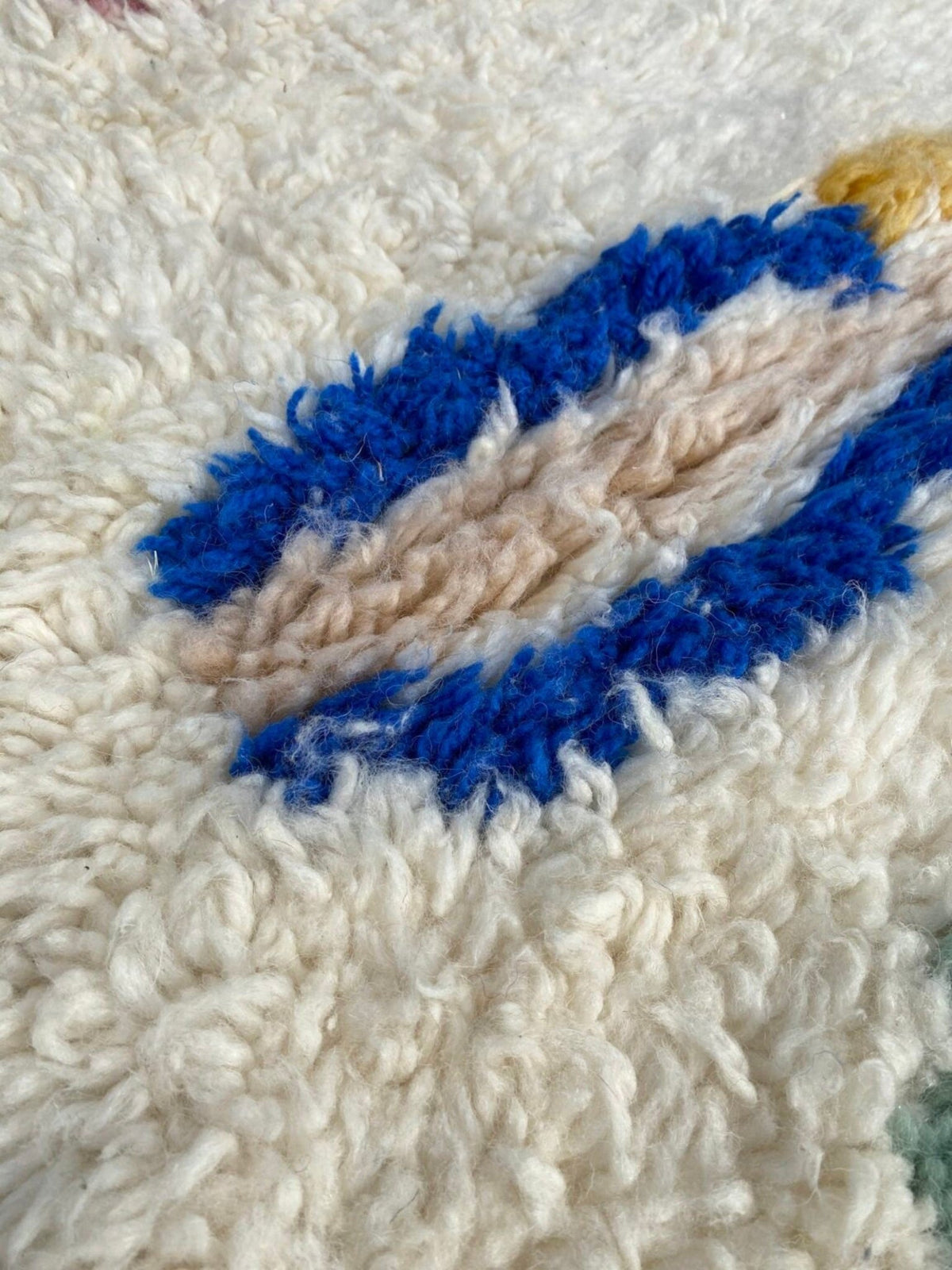 Close-up detail of a bohemian rug featuring textured fibers and a colorful pattern.