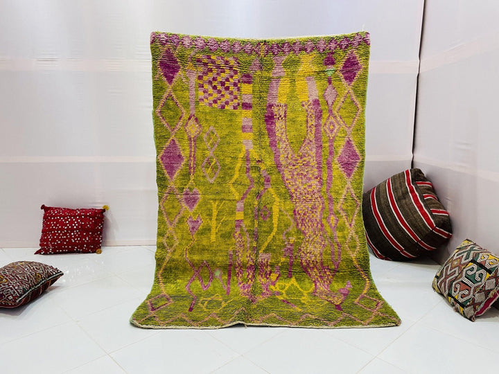 Lifestyle shot of a vintage Moroccan rug featuring green and yellow abstract patterns.