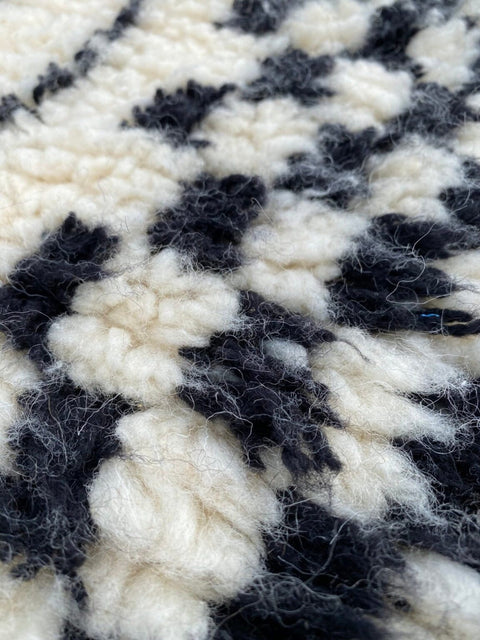 Detailed view showcasing the textured fibers and patterned weave of a black and white rug.