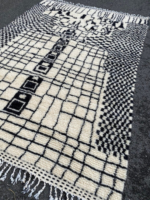 Close-up detail of the textured fibers and patterned weave of a black and white rug.