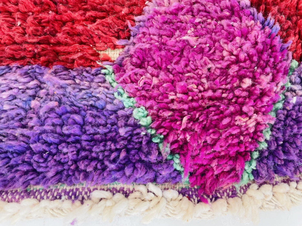 Lifestyle image of the green and purple Boujaad Moroccan rug featuring tribal patterns.