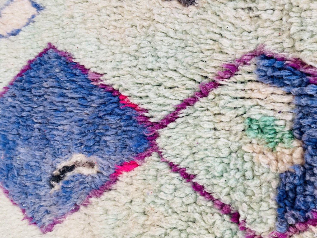 Close-up detail of the textured surface and tribal patterns on the Boujaad Moroccan rug.