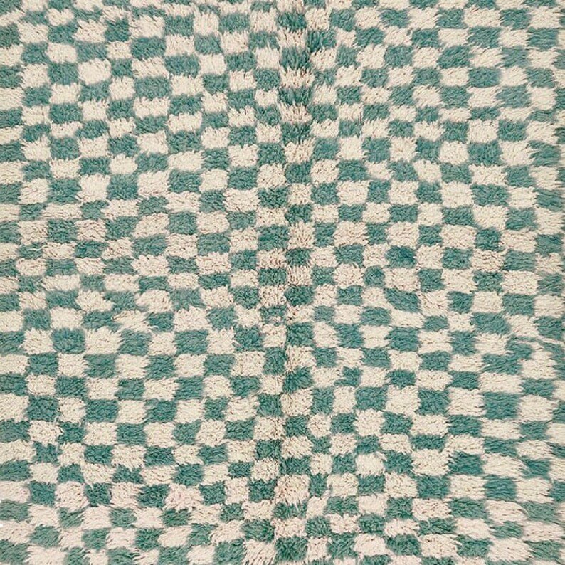 Close-up detail of the green checkered rug highlighting its tribal design.